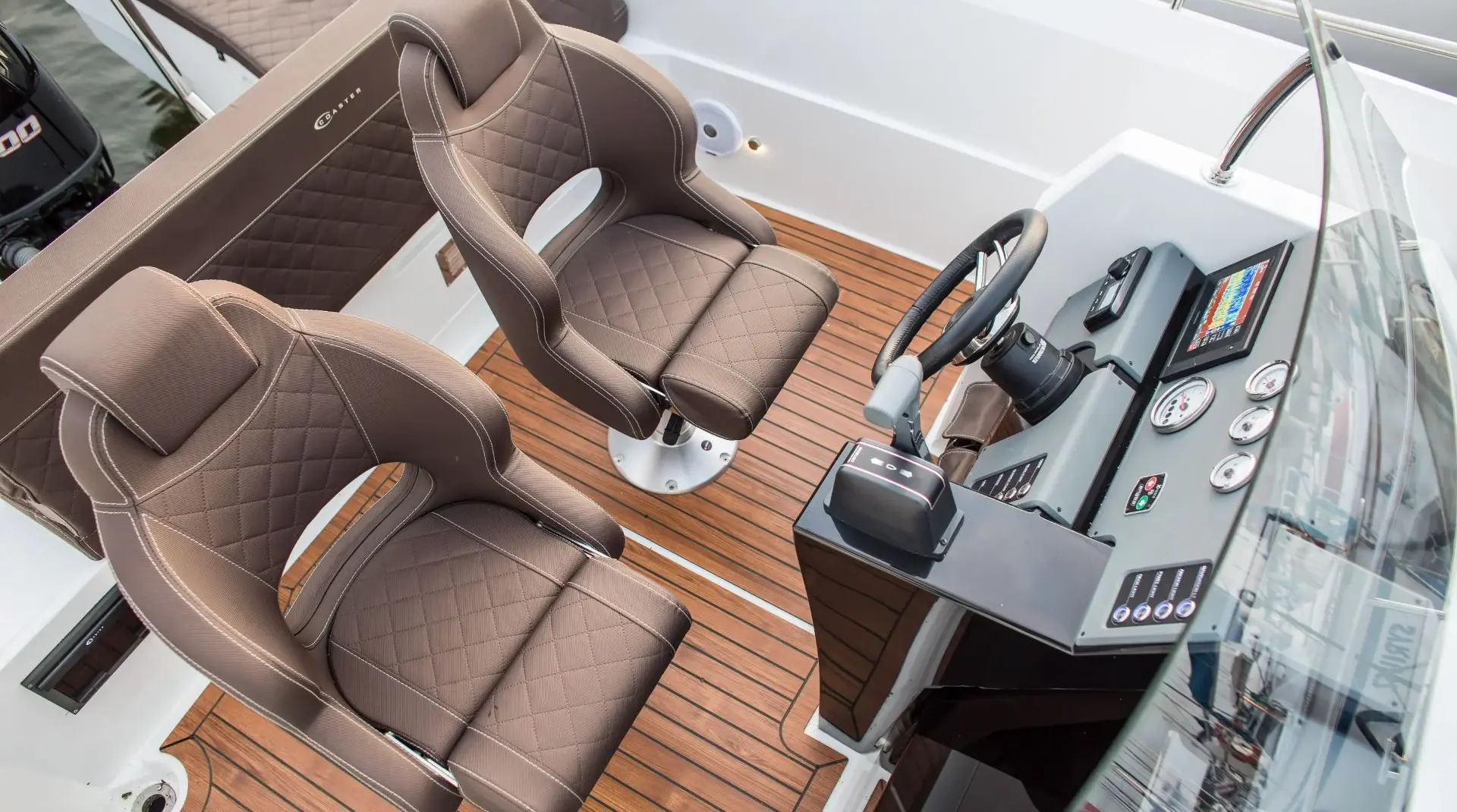 Steuerstand der Coaster 640 Sun mit gepolsterten Komfortsitzen, Teakoptik-Boden und moderner Instrumentierung im Cockpit.