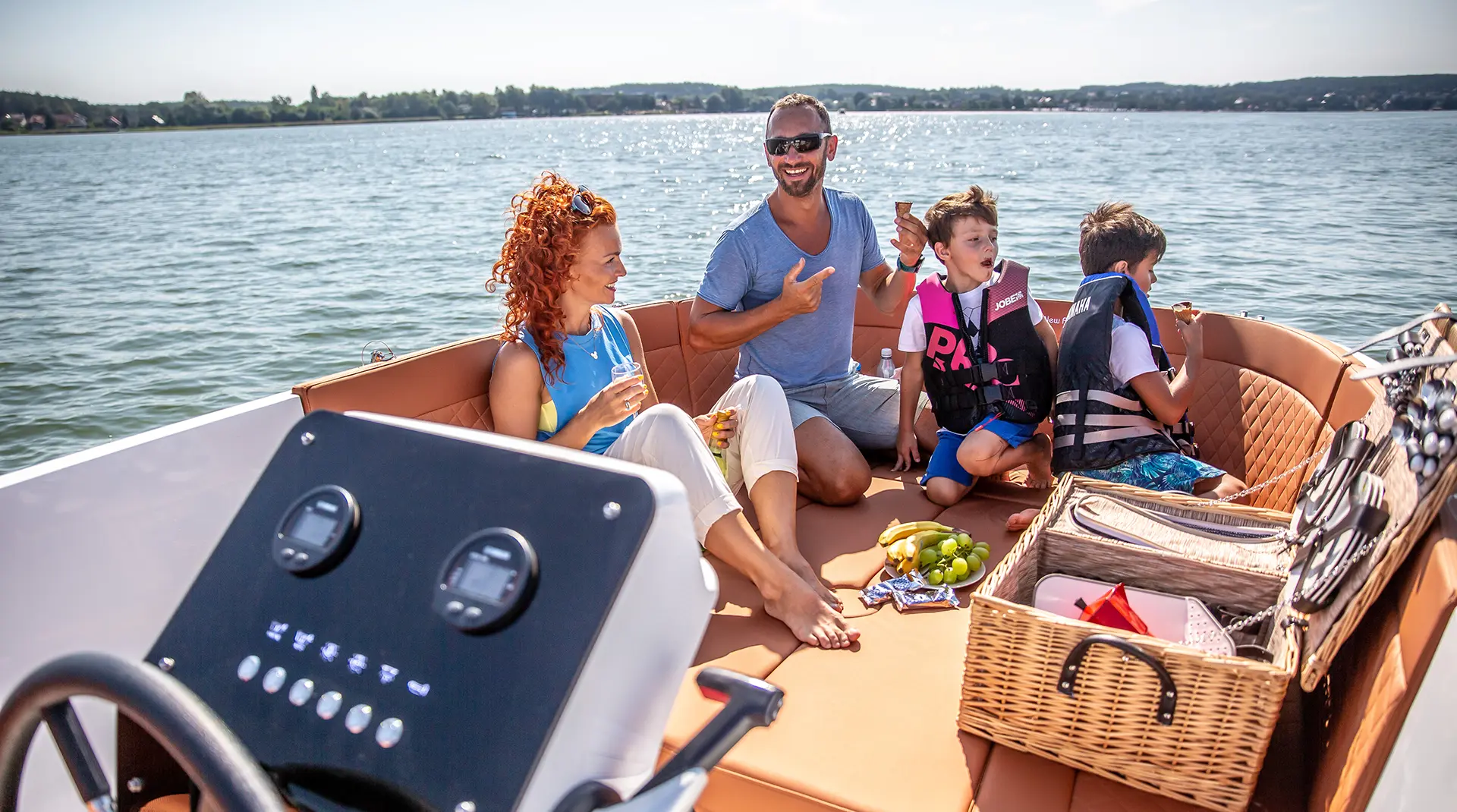 Familie genießt einen Ausflug an Bord der Corsiva 605 New Age auf einem See, mit großzügiger Sitzlandschaft und viel Platz zum Entspannen.
