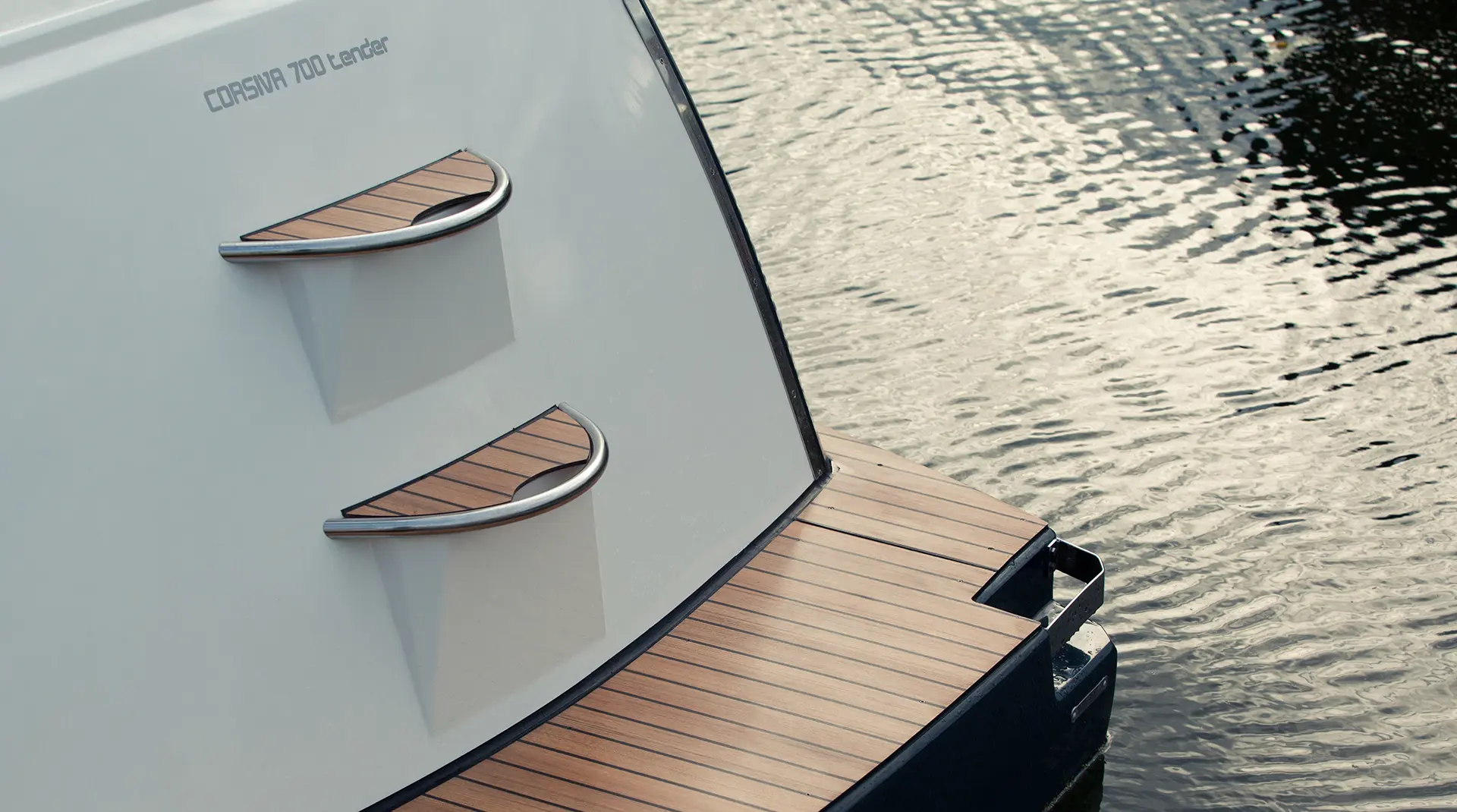 Heckbereich der Corsiva 700 Tender mit Badeplattform in Teakoptik und integrierter Badeleiter am Wasser.