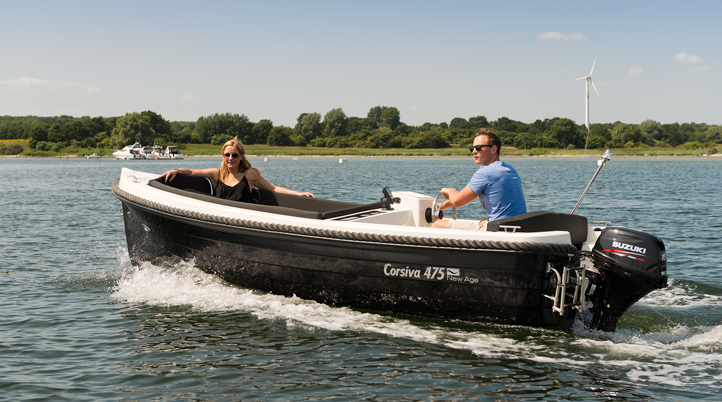 Corsiva 475 New Age mit zwei Personen an Bord auf einem See, elegantes Motorboot mit Außenbordmotor in Fahrt.