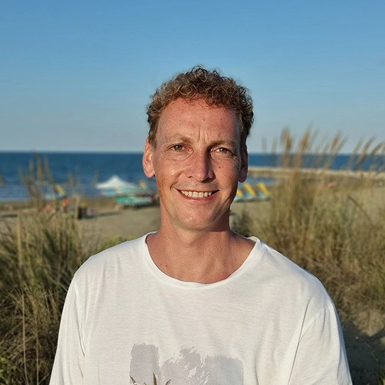 Porträt von Thomas Fuchs, Geschäftsführer von FOX Boote, im Freien vor einer Küstenlandschaft.