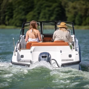 Coaster 515 BR Motorboot mit zwei Personen während der Fahrt auf einem See.