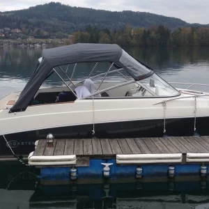Coaster 600 DC Motorboot mit geschlossenem Verdeck am Steg eines Sees.