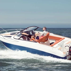 Coaster 600 DC Motorboot mit Familie an Bord während der Fahrt auf offenem Wasser.