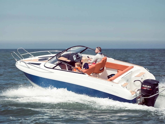 Coaster 600 DC Motorboot mit Familie an Bord während der Fahrt auf offenem Wasser.