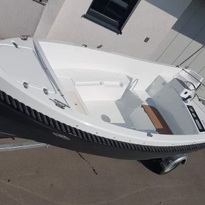 Frontansicht der Corsiva 475 New Age mit zwei Personen während einer Fahrt auf dem Wasser.