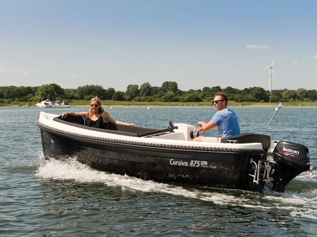 Corsiva 475 New Age Motorboot mit Suzuki Außenborder bei einer Fahrt auf dem See – kompaktes Familienboot mit großzügiger Sitzfläche und modernem Design.