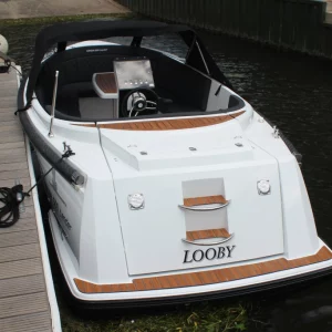 Corsiva 500 Tender Motorboot mit Badeplattform und Verdeck am Steg festgemacht.