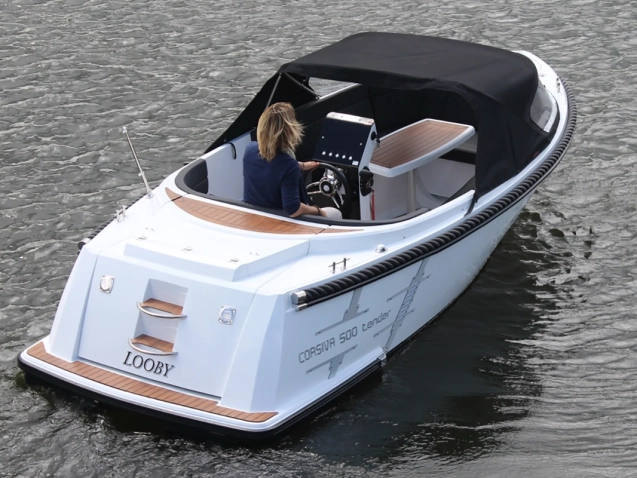 Corsiva 500 Tender Motorboot mit Verdeck auf ruhigem Gewässer, Heckansicht während der Fahrt.