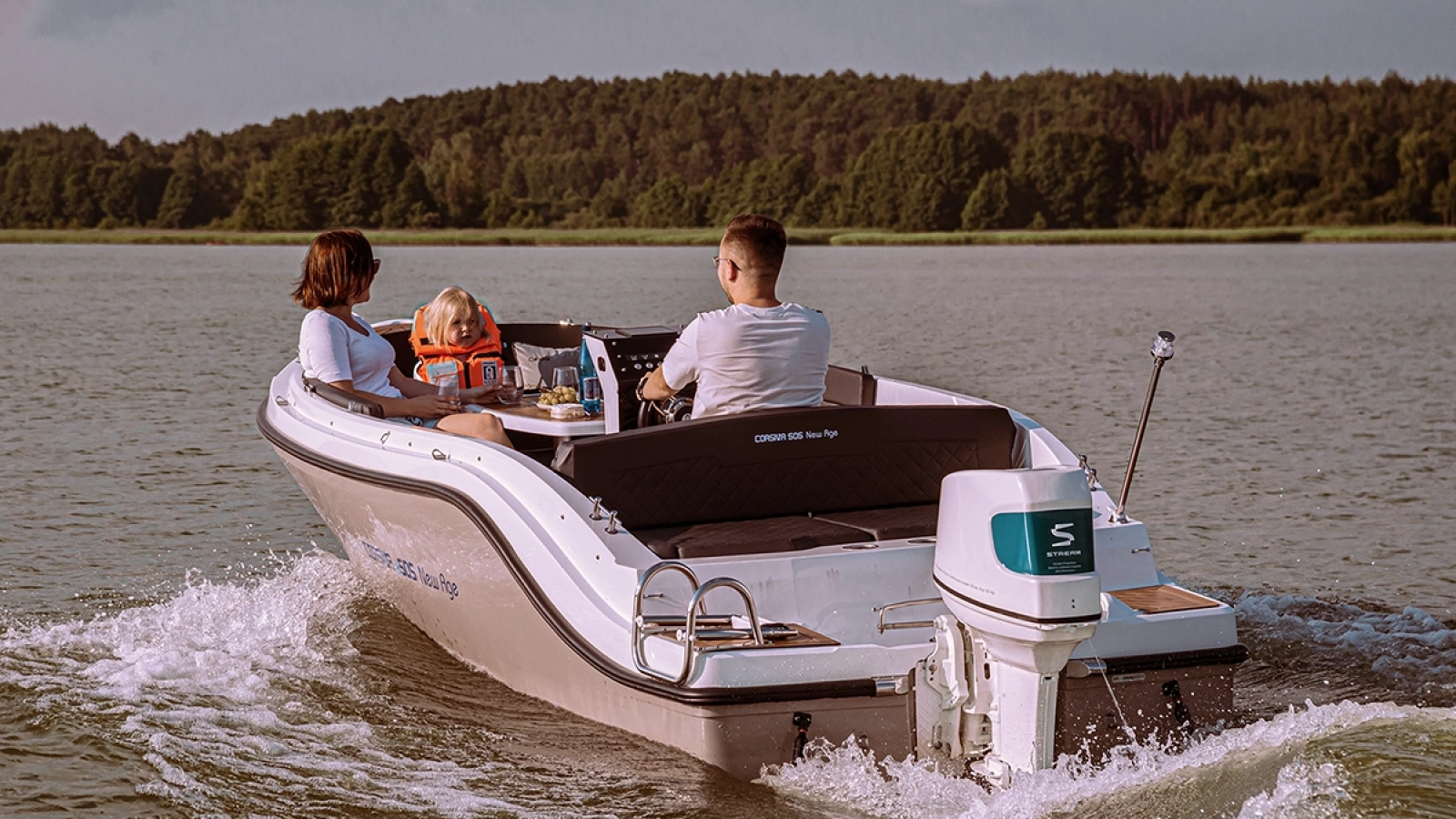 Corsiva 505 New Age mit Familie und elektrischem Außenbordmotor bei einer Fahrt auf dem See.