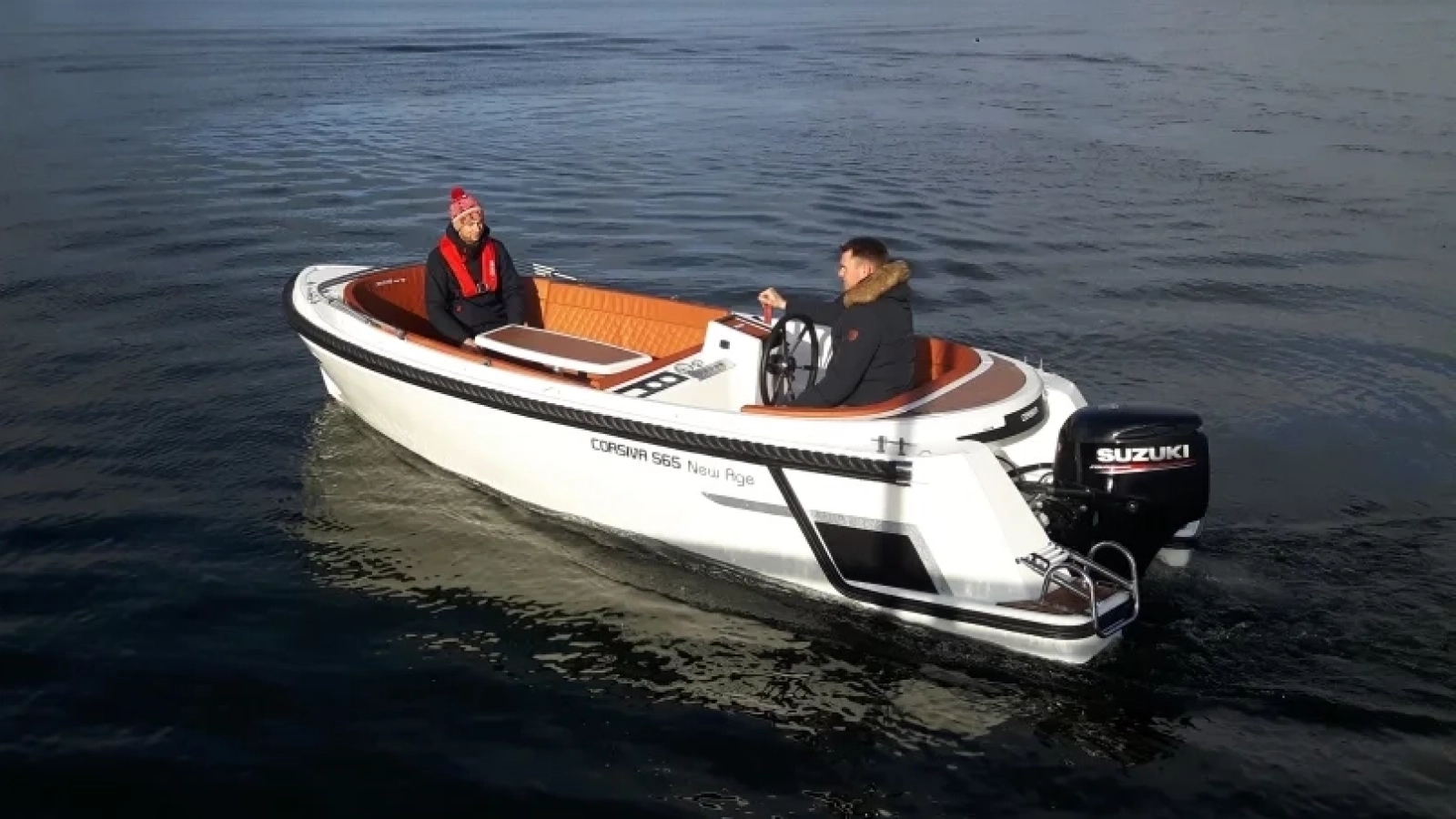 Corsiva 565 New Age mit Außenbordmotor auf ruhigem See während einer Ausfahrt mit zwei Personen an Bord.