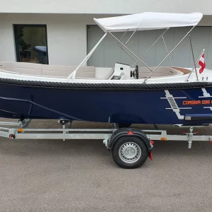 Seitenansicht der Corsiva 595 Tender auf Trailer mit Bimini und hochwertiger Ausstattung.