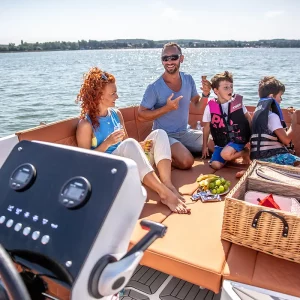 Familie genießt einen Sommertag auf der Corsiva 605 New Age mit gemütlicher Sitzgruppe und Picknick an Bord.