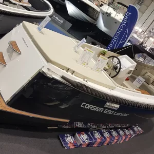 Schwarze Corsiva 690 Tender mit Badeplattform und hellem Cockpit auf einer Bootsmesse
