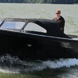 Schwarze Corsiva 690 Tender mit Verdeck während der Fahrt auf bewegtem Wasser