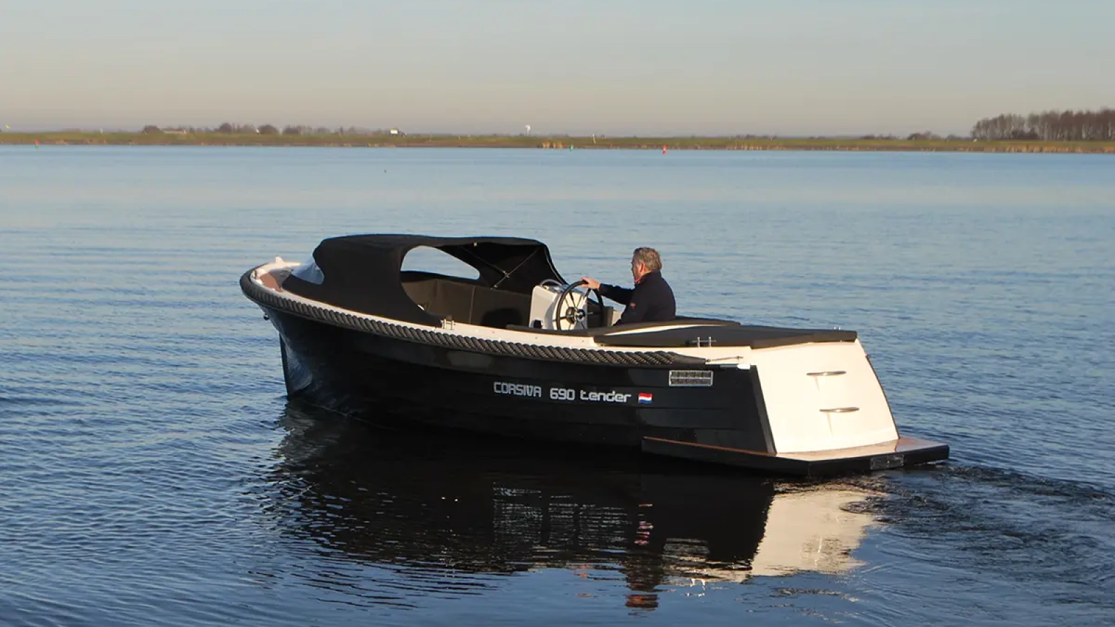 Corsiva 690 Tender mit Fahrer auf einem ruhigen See in seitlicher Heckansicht