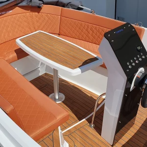 Cockpit der Corsiva 500 Tender mit orangefarbenen Polstern, Tisch und modernem Steuerstand.